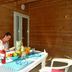 Lagrange Vacances Les Ségalières in Gramat, outdoor table on wooden terrace with fruit, drinks and seated guest