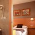 La City Estación Alicante bathroom with sink, wall-mounted hair dryers, and view into a twin guest room