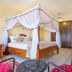 Rainbow Ruiru Resort Nairobi guest room with four-poster canopy bed and tiled floor