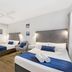Beach House Motel in Townsville: bright twin room with two beds, ceiling fan and framed wall art