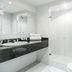 Travelers Condominio Plenitud in Bogotá bathroom with black vanity, glass shower, and toilet