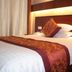 Yiwu Mango Hotel in Jinhua room with king bed, patterned runner, and upholstered headboard