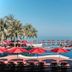 Khaolak Laguna Resort in Khao Lak with red umbrellas around a pool overlooking the ocean
