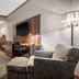Norfolk Lodge & Suites, Norfolk hotel room with desk, TV, armchair and entryway
