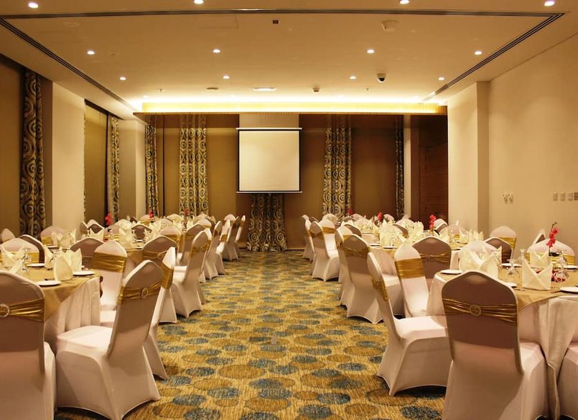 White Fort Hotel Dubai banquet hall with round tables and white chair covers