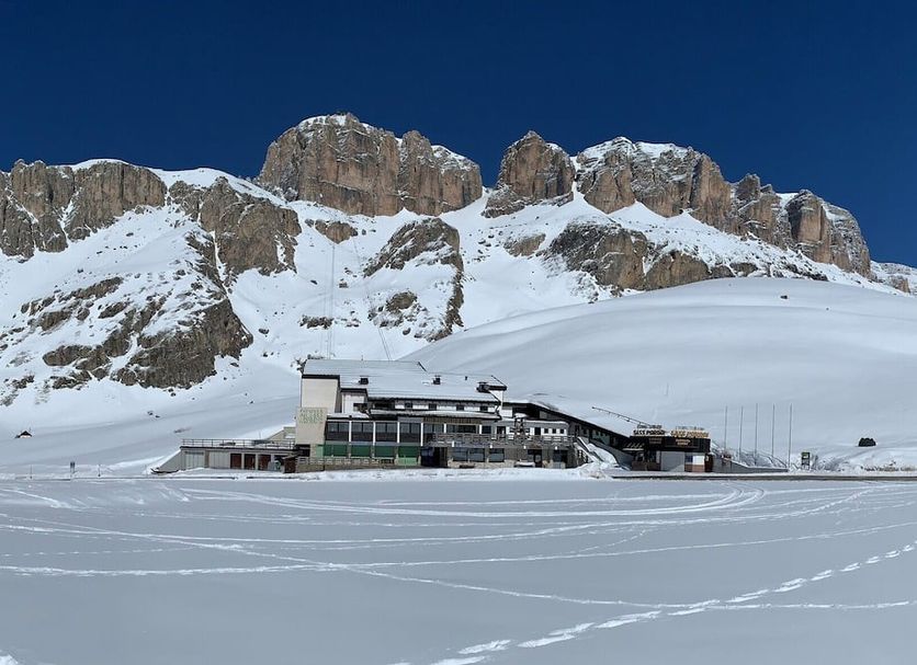 Hotel Col di Lana in Canazei with snowy mountain backdrop and ski slopes