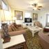 Desoto Beach Terraces in Tybee Island living room with sofa, armchairs, coffee table, TV, and ceiling fan