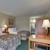 Vagabond Inn Ventura guest room with two double beds, lamps, desk and wardrobe in Ventura