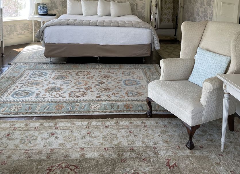 Moseley Cottage Inn and The Town Motel in Bar Harbor guest room with bed, patterned rugs, and armchair