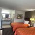 Loyalty Inn Hawkinsville guest room with two double beds and bathroom vanity