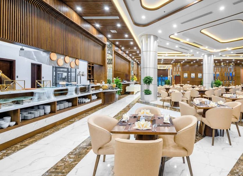 Alan Sea Hotel Danang dining room in Da Nang with beige chairs, marble floors and buffet counters