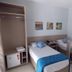 Atlas Hotel - Centro Palmas twin guest room with two single beds, wardrobe, mini fridge and wall art