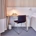 Ikea Hotell Älmhult guest room with desk, chair, lamp and bed beside a curtain