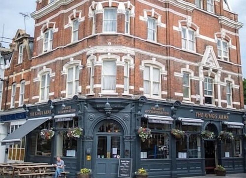 The Kings Arms London exterior, red-brick corner building with pub-style ground floor and hanging flower baskets