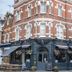 The Kings Arms London exterior, red-brick corner building with pub-style ground floor and hanging flower baskets