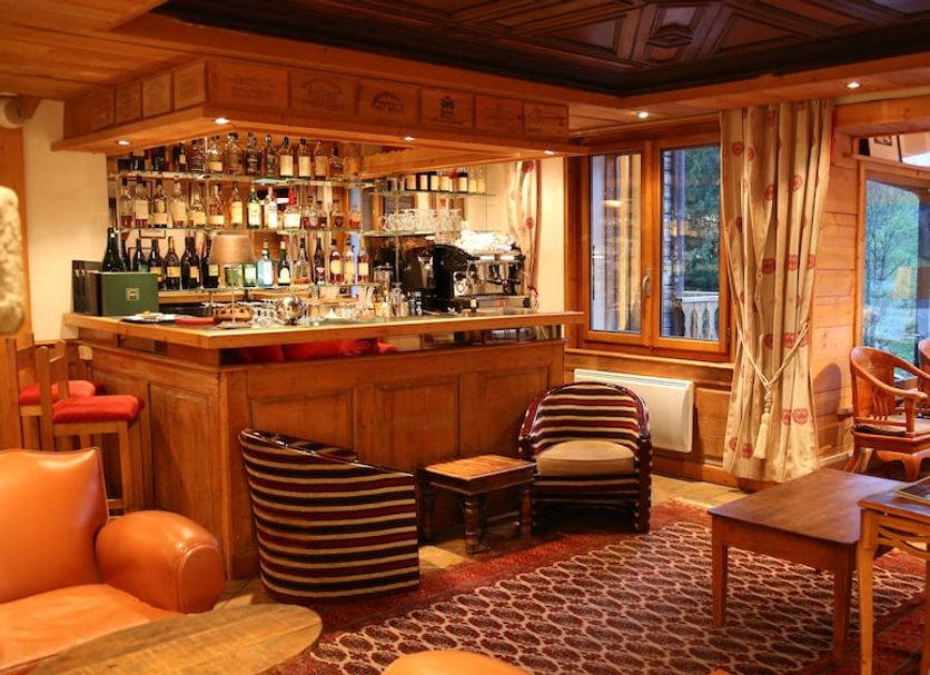 Le Jeu de Paume in Chamonix lounge with wood-paneled bar, patterned seating, and mountain-view windows
