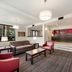 Lobby seating area at Red Roof Inn Birmingham South in Birmingham with red chairs, sofa, and front desk
