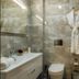 Yildiz Life Hotel Trabzon bathroom with glass shower, vanity, and hanging bathrobe