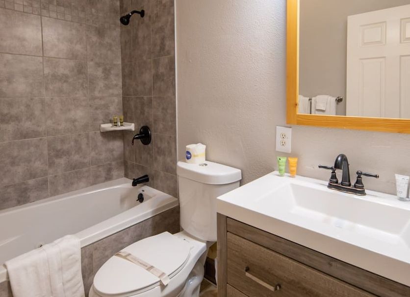 Emerald Bay Lodge bathroom in South Lake Tahoe with tub-shower, toilet, vanity sink and mirror