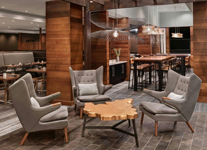 Cleveland Marriott East lounge in Warrensville Heights with gray chairs, wood tables, and bar seating