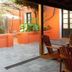 Hotel Beltran in Colonia del Sacramento patio with wooden chairs, table, and orange walls