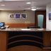 Motel 6 Little Rock, AR - Airport lobby front desk with check-in counter and wood flooring