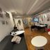 Svea Hostel Stockholm common lounge with red sofa, tables, dining area and wall art