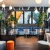 Leonardo Hotel Vienna Hauptbahnhof lounge with hanging globe lights, blue sofa, and abstract wall art in Vienna