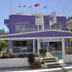 Dalyan Terrace Hotel in Dalyan, Mugla with a purple facade, flags, and covered terrace entrance