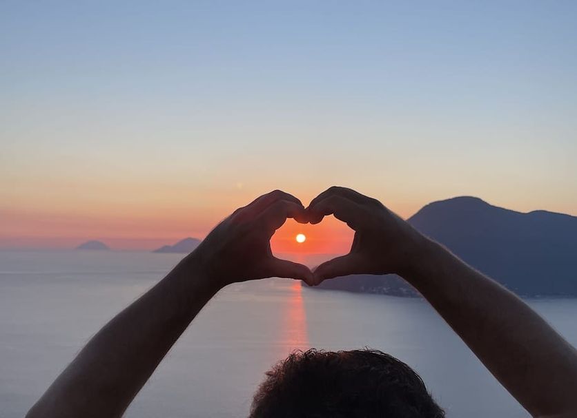 Hotel Villa Cute - Hvc in Lipari: hands forming a heart around the sunset over the sea and mountains