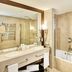 Sercotel Puerta de la Catedral in Salamanca bathroom with double sink, bathtub and glass shower enclosure