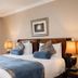 The Villa Rose Hotel & V-Spa in Ballybofey guest room with king bed, bedside lamps and window drapes
