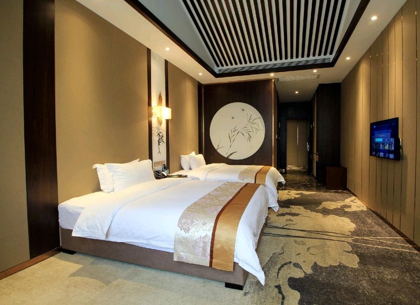 Jia Fu Li Jing Hotel in Guangzhou guest room with two neatly made beds and wall-mounted TV