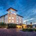 Hotel Indigo Jacksonville-Deerwood Park By IHG in Jacksonville at dusk, exterior with lit entrance and brick drive