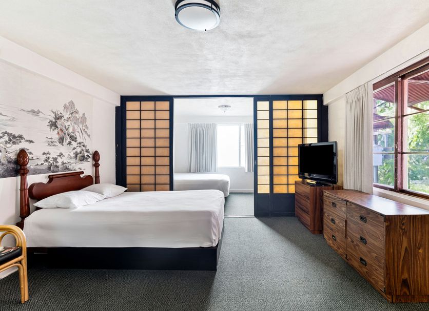 Royal Grove Waikiki guest room in Honolulu with twin beds, TV, dresser and window view