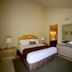 4 Seasons at Desert Breezes Palm Desert guest room with queen bed, dresser and mirror