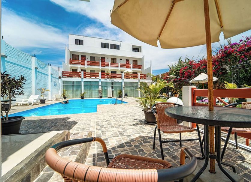 Hotel Residencial Los Frayles in Paracas with outdoor pool, patio seating and lounge chairs