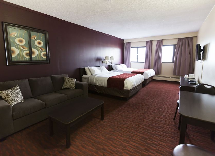 Argyll Plaza Hotel Edmonton room with two beds, sofa, desk, and window view