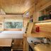 Postcard Cabins Asheboro cabin interior with loft bed, kitchenette, and forest view window