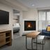 Homewood Suites by Hilton Alexandria/Pentagon South living area with fireplace, sofa, chair and coffee table