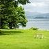 Towada Prince Hotel in Kosaka with a lakeside lawn, two chairs, and mountain views