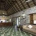 Halez Sparsa Thiruvannamalai lobby with stone walls, thatched ceiling, and green tiled floor in Tiruvannamalai