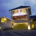 Hotel Tibera Taman Cibeunying in Bandung, lit exterior entrance at dusk with driveway