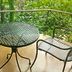 Amphawa Club Resort & Spa balcony with round metal table and two chairs among lush greenery in Amphawa