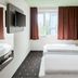 B&B Hotel Frankfurt-West room with twin beds, wall-mounted TV and cityscape wall art in Frankfurt am Main