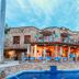 Casa Lisa in Acapulco with a stone terrace and blue-lit pool at dusk