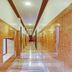 Hilltown Hotel in Madikeri hallway with glossy marble walls, recessed lights, and a long tiled corridor