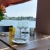 Hotel - Restaurant du Lac - Agen dining table by a lake view in Boé with flowers and wine glasses