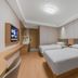 Tizi Hostel in Shanghai room with two single beds, wall-mounted TV, desk and compact bathroom area