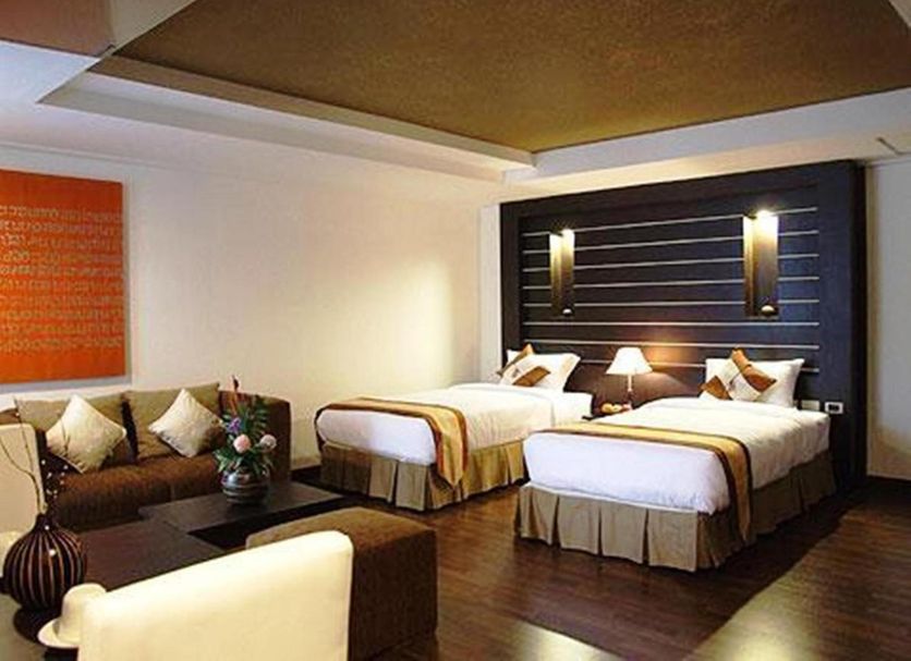 The Heritage Sathorn Suite Hotel Bangkok guest room with two beds and sofa seating